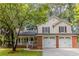 Charming two-story home with a brick garage, light siding, a porch, and a beautifully landscaped front yard at 3614 Spring Leaf Ln, Acworth, GA 30101