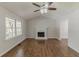 Spacious living room featuring a ceiling fan, brick fireplace, large windows, and wood-look flooring throughout at 3614 Spring Leaf Ln, Acworth, GA 30101