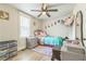 Bright bedroom features a ceiling fan, window with blinds, and colorful decor for a playful atmosphere at 1035 Cornish Mountain Church Rd, Oxford, GA 30054