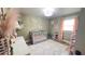 Charming Bedroom with a gray crib, pink accents, and hardwood floors at 1035 Cornish Mountain Church Rd, Oxford, GA 30054