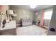 Comfortable Bedroom featuring a gray crib, hardwood floors, and pink decorative elements at 1035 Cornish Mountain Church Rd, Oxford, GA 30054