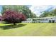 Charming ranch-style home with a well-maintained lawn and a large tree in a partially wooded lot at 1035 Cornish Mountain Church Rd, Oxford, GA 30054