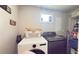 Well-lit laundry room with washer, dryer, shelving, and a convenient window at 1035 Cornish Mountain Church Rd, Oxford, GA 30054