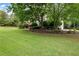 Landscaped front yard with mature trees, shrubs, and a well-maintained lawn at 1850 Kirkmont Nw Dr, Marietta, GA 30064