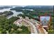 Beautiful aerial view of lakeside townhomes surrounded by lush trees and glistening water at 1969 Lanier Harbor Pt, Buford, GA 30518