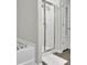 Elegant bathroom with a glass door shower, soaking tub, and pristine white tile, blending luxury and functionality at 1969 Lanier Harbor Pt, Buford, GA 30518