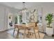 Sunlit dining area with modern light fixture, stylish furniture, and access to patio at 1969 Lanier Harbor Pt, Buford, GA 30518