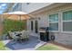 Outdoor dining and grill area features a dining table with umbrella, grill, and privacy wall with lush green vines at 1969 Lanier Harbor Pt, Buford, GA 30518