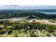 Aerial view showcasing the home's location near a school, wooded areas, and a lake in the distance at 7090 Valley Landing Ct, Cumming, GA 30041
