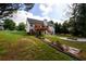 Expansive backyard featuring a deck, stone patio, and lush green lawn perfect for outdoor activities at 7090 Valley Landing Ct, Cumming, GA 30041