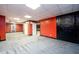 Finished basement with plush gray carpeting, red walls, and a white ceiling, creating a comfortable living space at 7090 Valley Landing Ct, Cumming, GA 30041