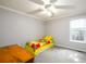 Cozy bedroom with natural light, a bright quilt, and neutral carpeting at 7090 Valley Landing Ct, Cumming, GA 30041