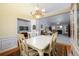 Open dining room with a view into the living area, featuring an elegant chandelier and hardwood floors at 7090 Valley Landing Ct, Cumming, GA 30041