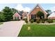 Charming brick home with a well-manicured lawn, complemented by mature trees and a paved driveway at 7090 Valley Landing Ct, Cumming, GA 30041