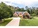 Charming brick home with a well-manicured lawn, inviting entrance, and long driveway at 7090 Valley Landing Ct, Cumming, GA 30041