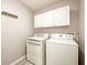 Functional laundry room with white washer, dryer, and cabinetry for storage at 7090 Valley Landing Ct, Cumming, GA 30041