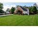 Expansive, well-maintained lawn surrounds the charming home, complemented by mature trees in the background at 7090 Valley Landing Ct, Cumming, GA 30041
