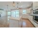 Open kitchen with stainless steel appliances, quartz countertop island, and hardwood flooring at 146 Himalaya Way, Mcdonough, GA 30253