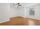 Bedroom with hardwood flooring, ceiling fan, and a large window with a green outdoor view at 2379 Fallbrook Ct, Duluth, GA 30096