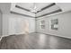 Bright bedroom with hardwood floors, a tray ceiling, and a ceiling fan at 2379 Fallbrook Ct, Duluth, GA 30096