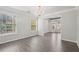 Bright living room with gray wood flooring, chandelier and large windows with backyard views at 2379 Fallbrook Ct, Duluth, GA 30096