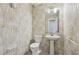 Powder room features decorative wallpaper, toilet and a pedestal sink with gold hardware at 2379 Fallbrook Ct, Duluth, GA 30096