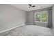 Gray carpeted bedroom features a window with curtains and a ceiling fan at 2680 Pine Tree Ne Rd # 2, Atlanta, GA 30324