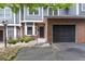 Close-up of a well-maintained townhome featuring brick accents, garage, and landscaped front yard at 2680 Pine Tree Ne Rd # 2, Atlanta, GA 30324
