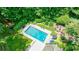 Aerial view of the backyard with an in-ground pool, patio with umbrellas, and a beautifully landscaped yard at 510 Heards Ferry Rd, Atlanta, GA 30328