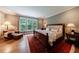 Tranquil main bedroom with hardwood floors, a large bed, and a view of the trees at 510 Heards Ferry Rd, Atlanta, GA 30328