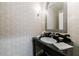 Elegant powder room with a stylish vanity, designer mirror, and patterned wallpaper for a luxurious touch at 510 Heards Ferry Rd, Atlanta, GA 30328