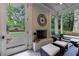 Sunroom features a brick fireplace, ample seating, and a view of the surrounding lush landscape at 510 Heards Ferry Rd, Atlanta, GA 30328