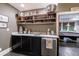 Wet bar boasts sleek black cabinetry, a marble countertop, and open shelving for glassware, perfect for entertaining at 510 Heards Ferry Rd, Atlanta, GA 30328