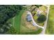 An aerial view captures a modern home on a spacious lot with verdant landscaping, a long driveway, and nearby outbuildings at 5315 Hendrix Rd, Cumming, GA 30040