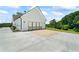 Side view of a spacious three-car garage with a long concrete driveway and farmhouse-style doors at 5315 Hendrix Rd, Cumming, GA 30040