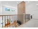 Upstairs hallway boasts views of the lower level with a decorative brick wall element at 5315 Hendrix Rd, Cumming, GA 30040