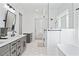 Bright bathroom showcasing dual sinks, frameless glass shower, freestanding tub, and hexagon tile flooring at 5315 Hendrix Rd, Cumming, GA 30040
