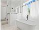 Bright bathroom showcasing a freestanding tub, frameless glass shower, and hexagon tile flooring, with window at 5315 Hendrix Rd, Cumming, GA 30040