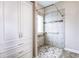 Bright bathroom showcasing a spacious walk-in shower with tiled walls and custom storage cabinet at 6470 Saint Mark Way, Fairburn, GA 30213