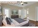 Staged bedroom featuring a comfortable bed, dresser, and modern decor with view into the bathroom at 6470 Saint Mark Way, Fairburn, GA 30213