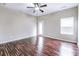 A bright bedroom has wood floors, a ceiling fan, and natural light at 6470 Saint Mark Way, Fairburn, GA 30213