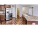 Kitchen area with stainless steel refrigerator, granite countertops, and hardwood floors, creating a modern, functional space at 6470 Saint Mark Way, Fairburn, GA 30213
