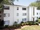 An eye-level view of this white brick complex with black framed windows and a manicured lawn and shrubbery at 1120 Briarcliff Ne Rd # 5, Atlanta, GA 30306