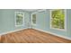 Bright bedroom featuring wood-look floors, three windows and a ductless air conditioning unit at 2199 Clairmont Cir, Snellville, GA 30078