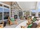 Outdoor lounge area with comfortable seating, a stone fireplace, and large windows at 3442 Fishpond Cir, Dacula, GA 30019