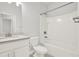 Bright bathroom with shower-tub combo, white tile, and vanity with solid surface countertop at 509 Grace Ln, Villa Rica, GA 30180