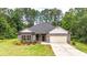 Charming single-story home featuring brick accents, a well-manicured lawn, and attached two car garage at 509 Grace Ln, Villa Rica, GA 30180