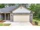 Close up of the home's garage, showcasing the brick facade, landscaping, and modern lighting at 509 Grace Ln, Villa Rica, GA 30180