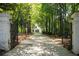 Gated driveway leading to a stately home, surrounded by mature trees and lush landscaping at 1016 Old Powers Ferry Rd, Atlanta, GA 30327
