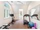 Well-lit exercise room featuring large windows, a stationary bike, treadmill, and exercise equipment at 1016 Old Powers Ferry Rd, Atlanta, GA 30327